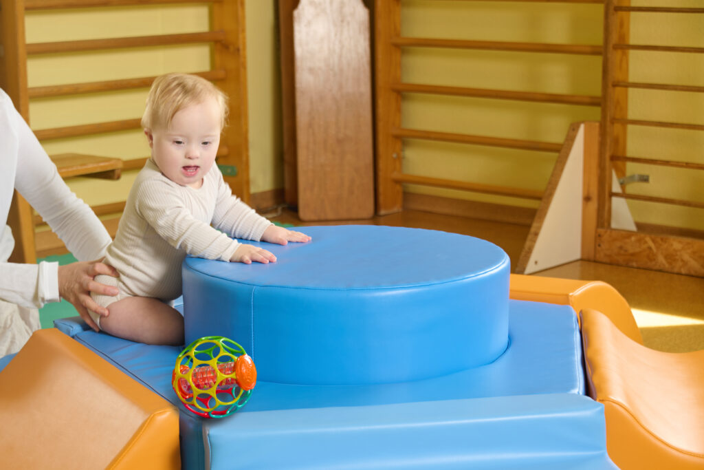 Baby mit Ball auf Physio-Turm